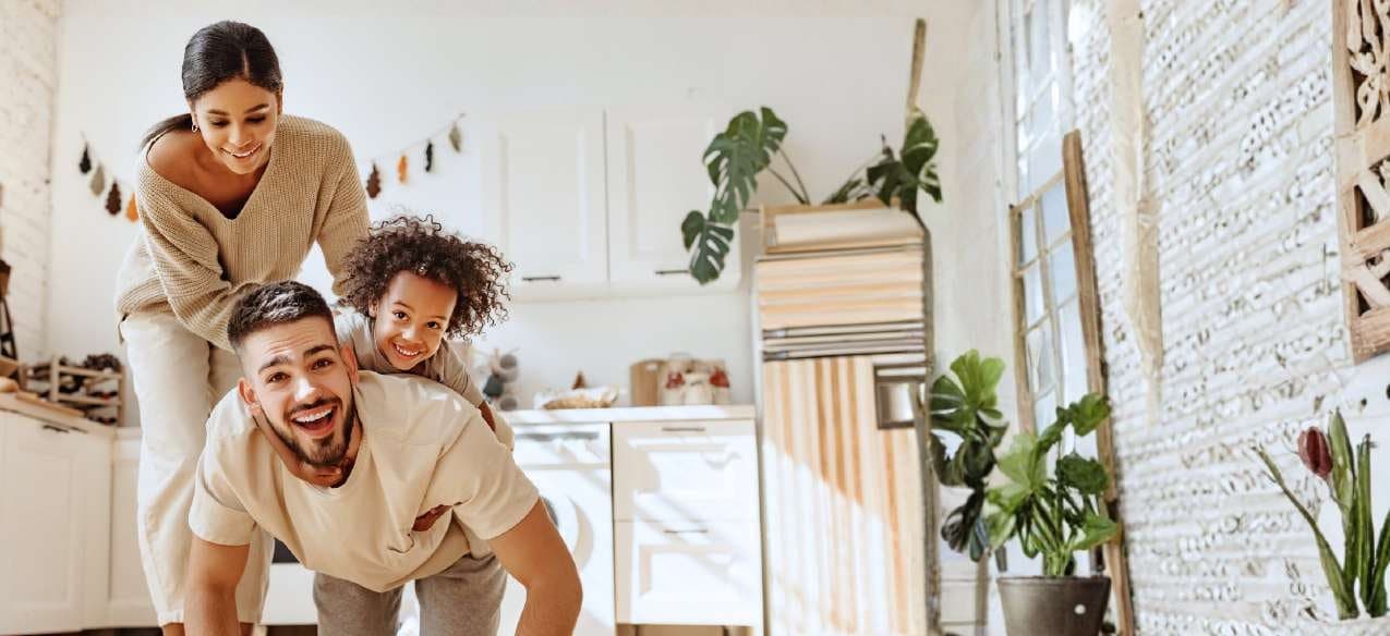A family laughing together in a bright kitchen