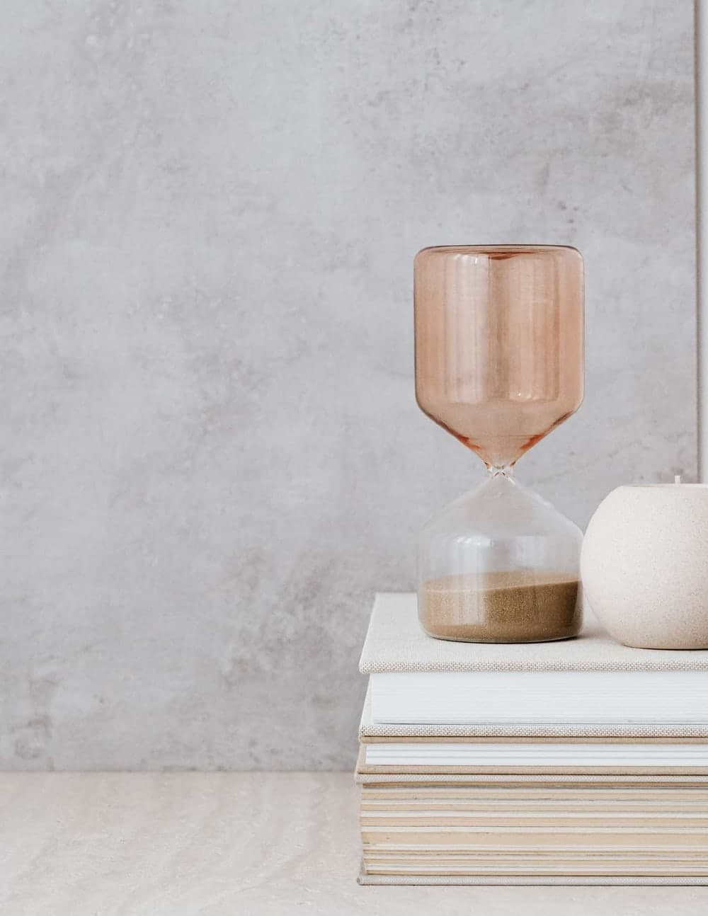 An hourglass resting on a stack of books